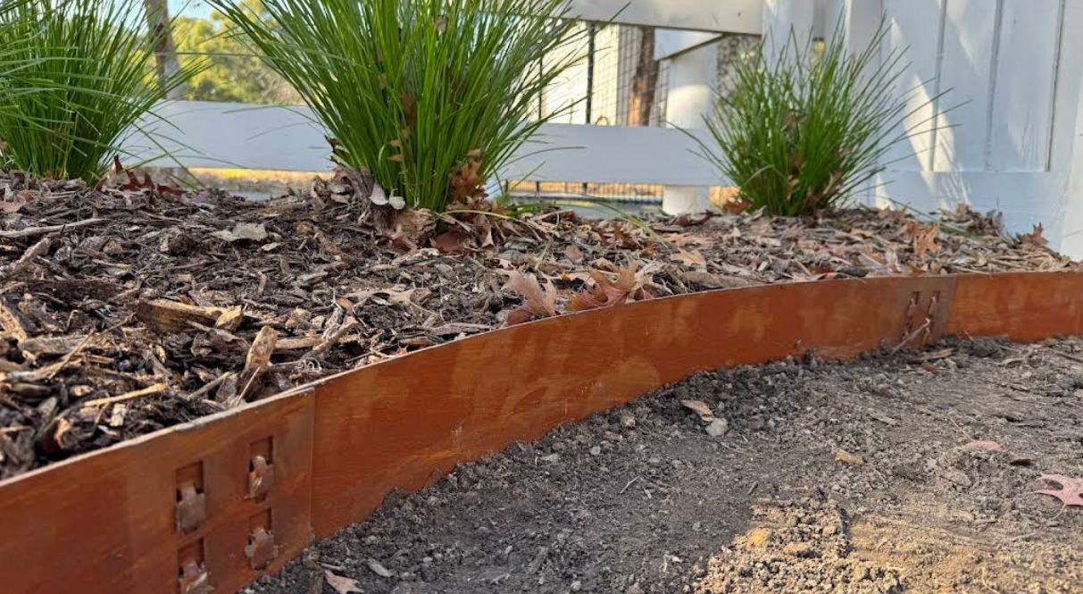 Corten steel garden edging bordering a mulched landscape bed