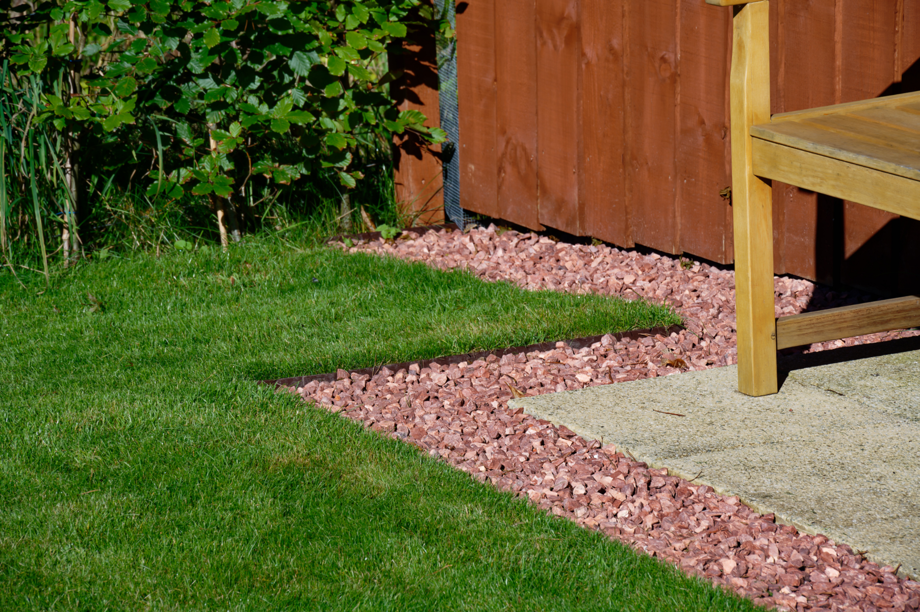 Garden edging creating a clean border between lawn, gravel and paving