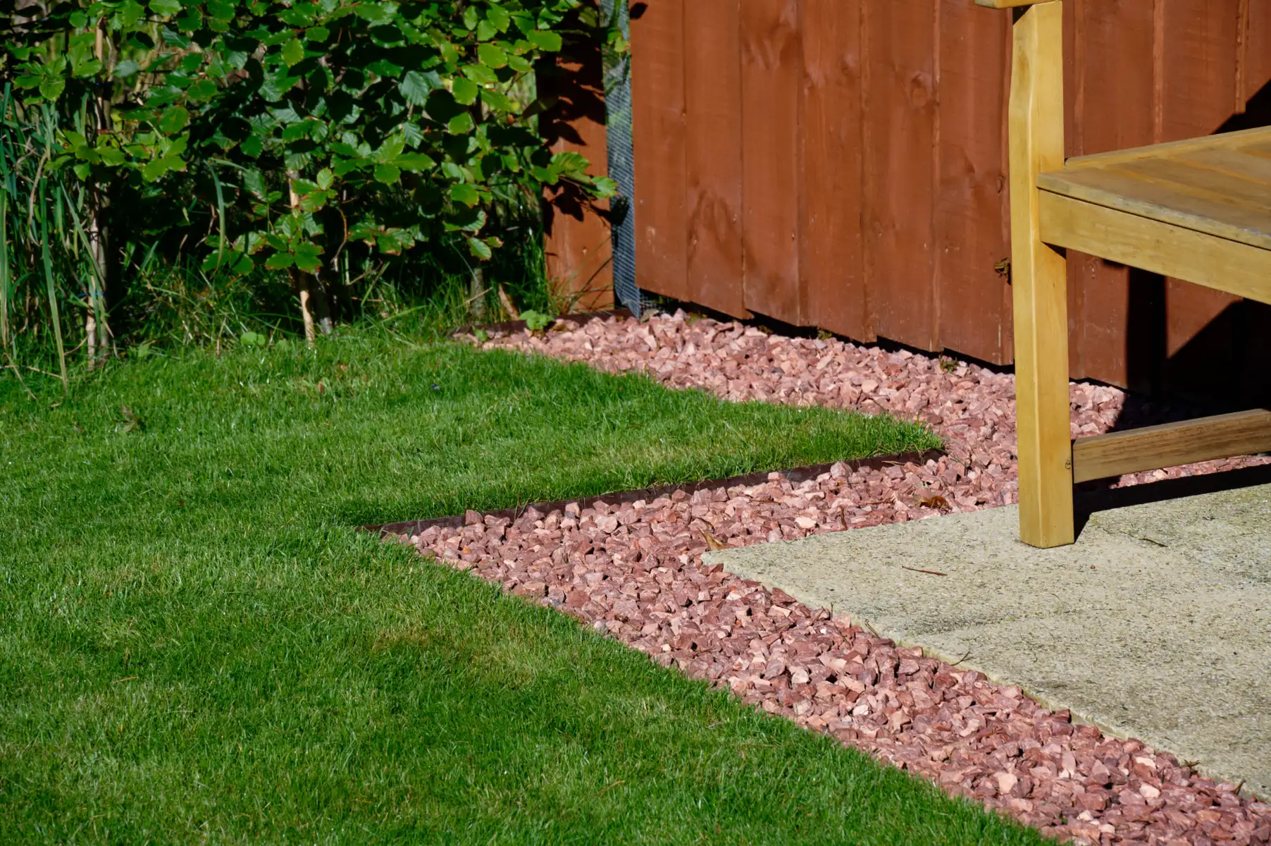 Garden edging creating a clean border between lawn, gravel and paving