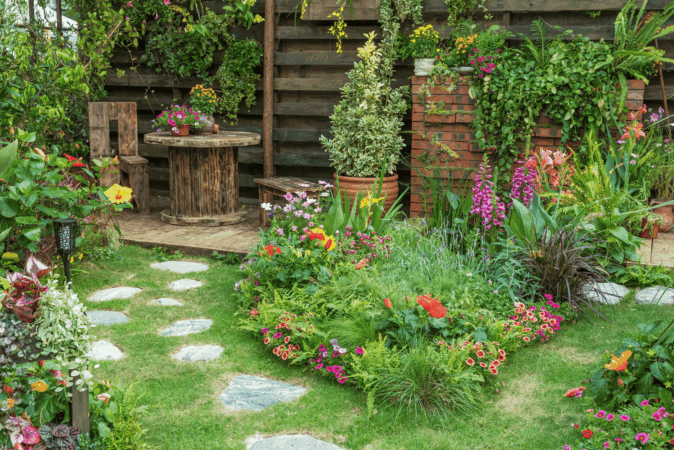 A garden with a stone path surrounded by colourful flowers.